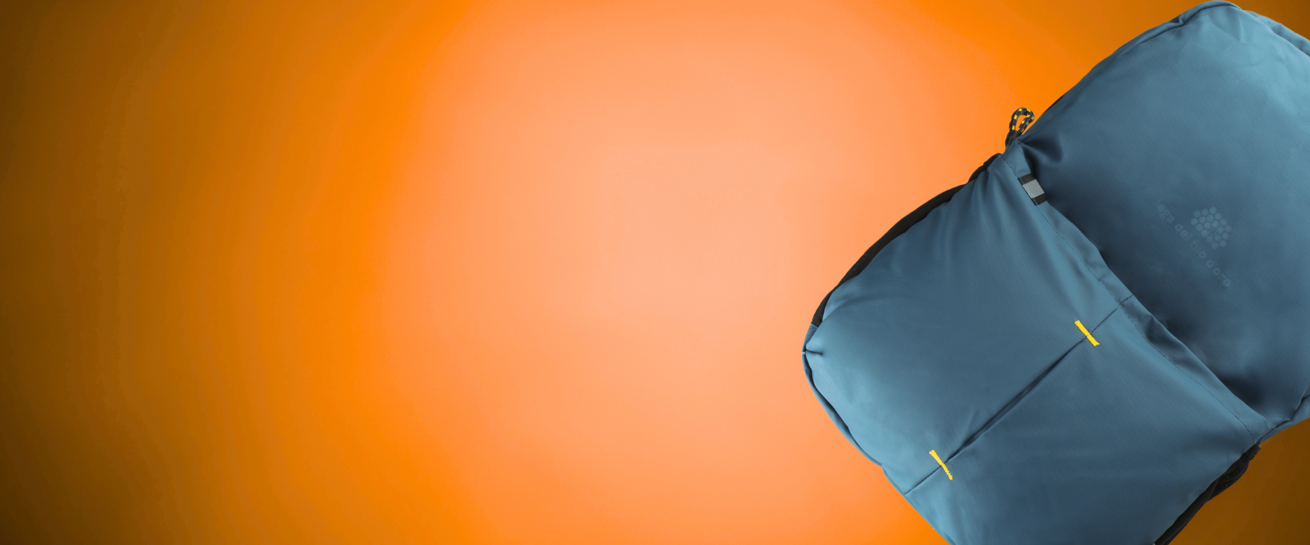 Foto su sfondo arancione dello zaino blu brandizzato con il logo della Lega del Filo d'Oro, uno dei prodotti solidali ordinabili sul sito