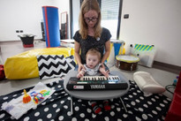 Il piccolo Gabriele, ospite del Centro Diagnostico, svolge un'attività educativo-riabilitativa con l'aiuto di una pianola che il bimbo suona sorretto dalla sua educatrice 