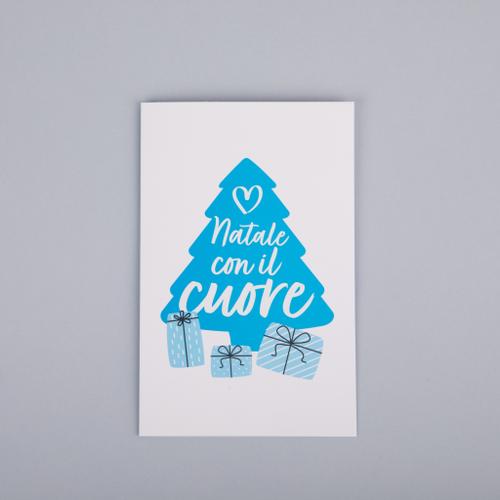 Biglietto di auguri con disegnata la sagoma di un grande albero di Natale azzurro con la scritta "Natale con il cuore" e 3 pacchetti regalo 1
