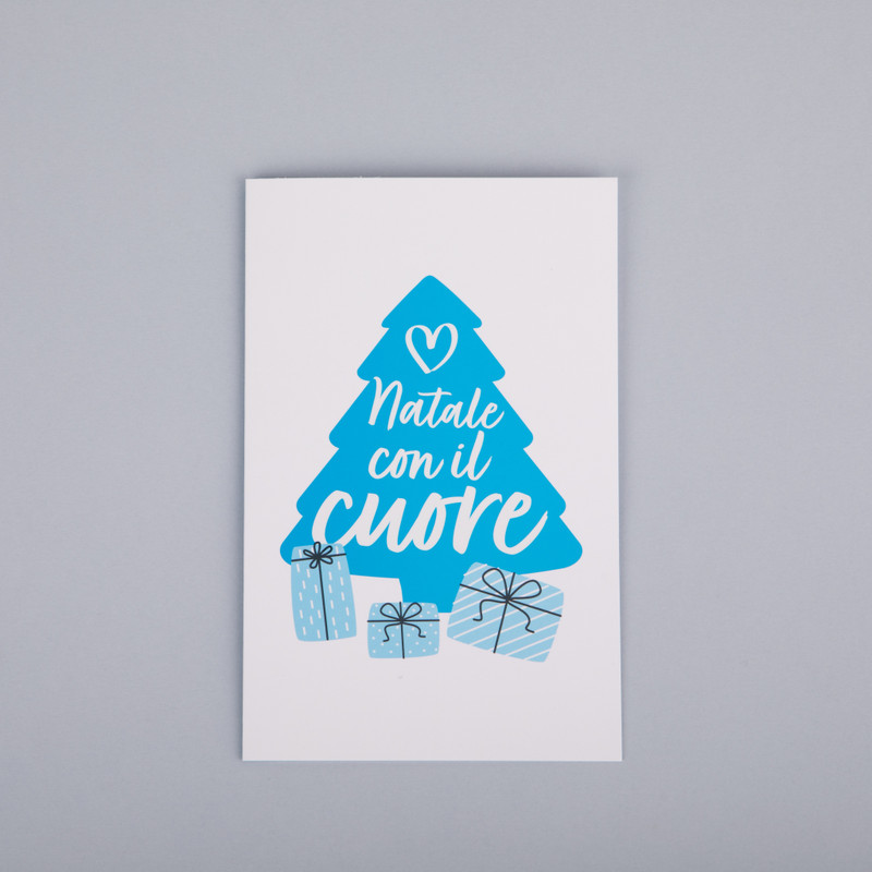 Biglietto di auguri con disegnata la sagoma di un grande albero di Natale azzurro con la scritta "Natale con il cuore" e 3 pacchetti regalo
