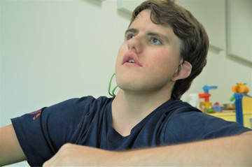 Ritratto di Thomas, ragazzo seguito dalla Lega del Filo d'Oro fin da quando era piccolo. Nella foto è seduto in un'aula del Centro Nazionale durante un soggiorno per trattamenti 