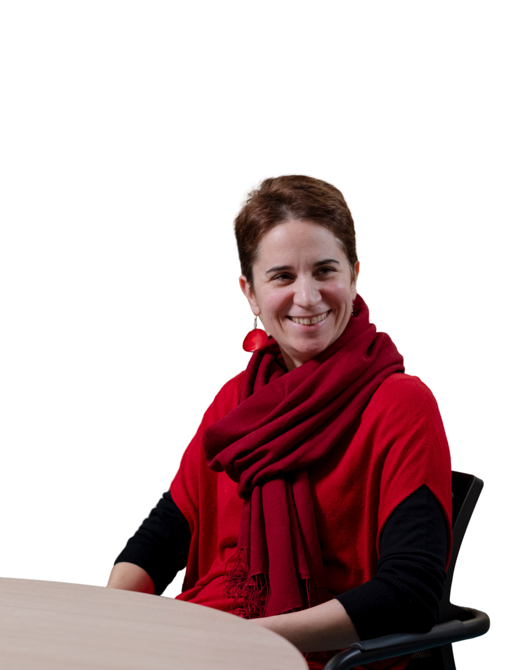 Virginia Lacaria sorride di fronte alla fotocamera. Indossa un maglione rosso a maniche corte, sotto un lupetto nero. Intorno al collo ha una sciarpa bordeaux e indossa degli orecchini pendenti rossi che richiamano il colore della maglia.