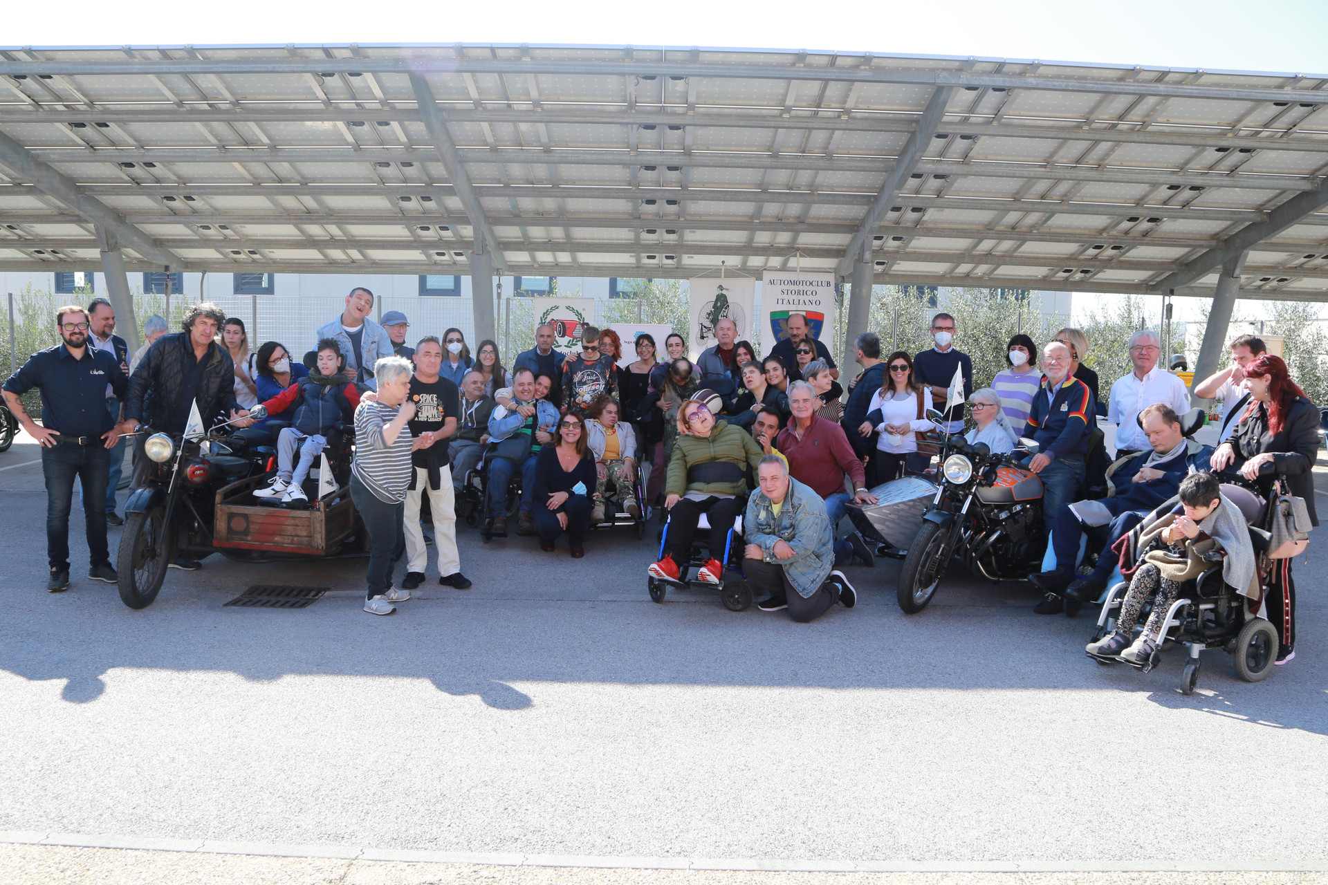 Una foto di gruppo che ritrae utenti e motociclisti con le loro belle moto in mostra, celebrando la passione per le due ruote e la condivisione di momenti speciali.