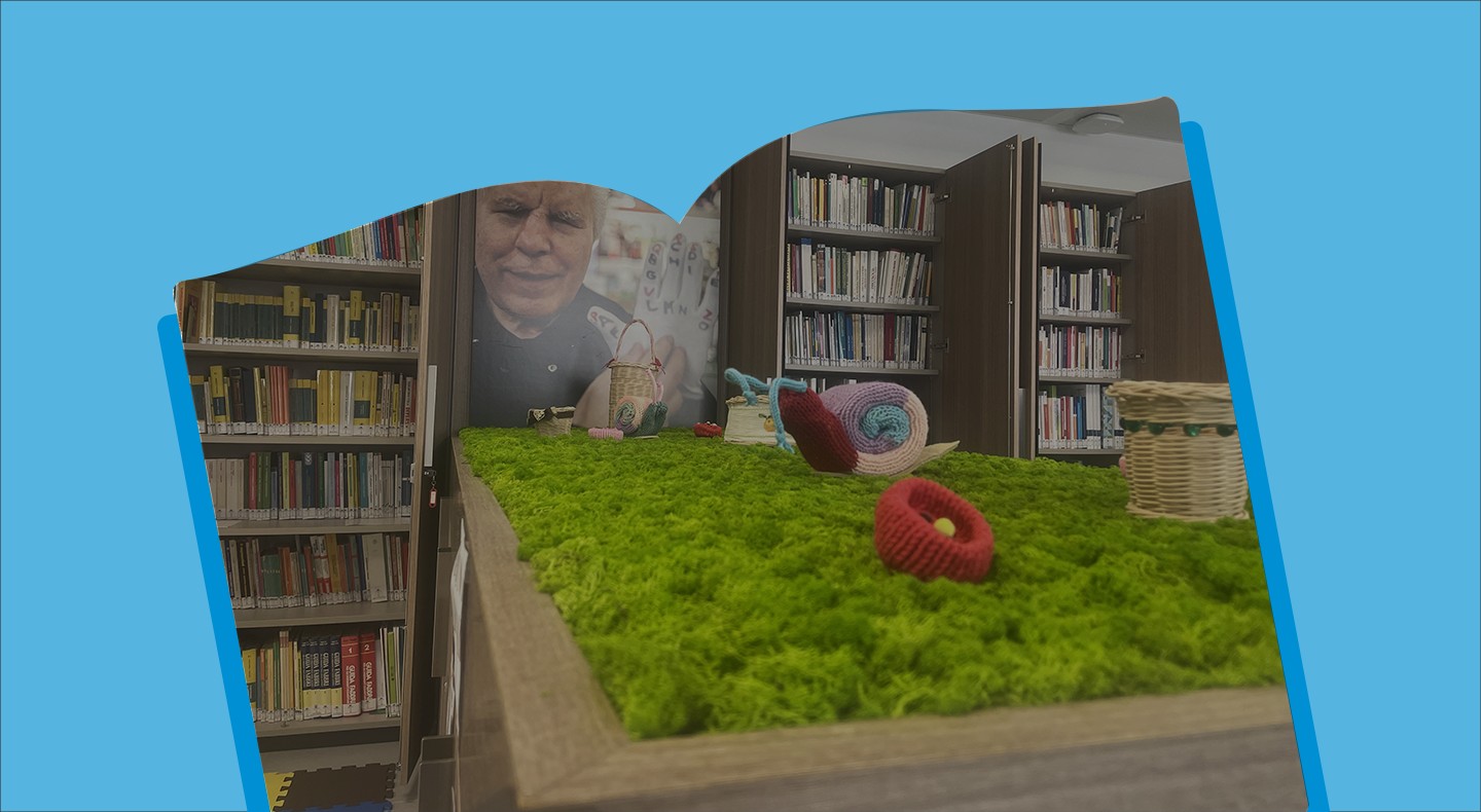 Spaccato della biblioteca con Libri sullo sfondo, l'immagine e all'interno di una cornice a forma di libro azzurra.