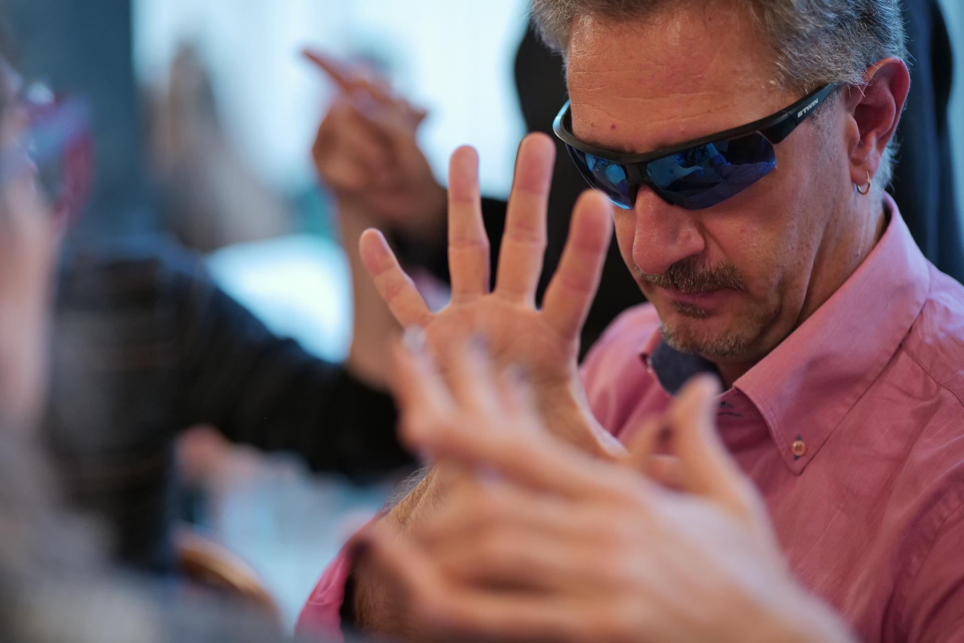 Alessandro Romano mentre comunica in LIS, alla Conferenza delle Persone Sordocieche, Tivoli 2023