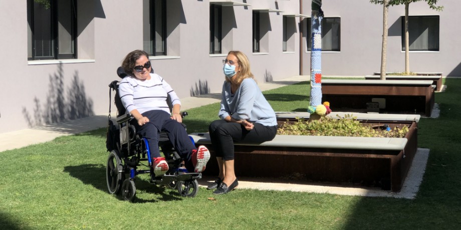 Paola, ospite residenziale del Centro Nazionale di Osimo, insieme a Nicoletta Marconi, direttrice Settore Trattamenti Estensivi e Servizi Territoriali. Sono nel cortile del Centro in una giornata soleggiata durante il periodo del Covid perchè Nicoletta indossa la mascherina.