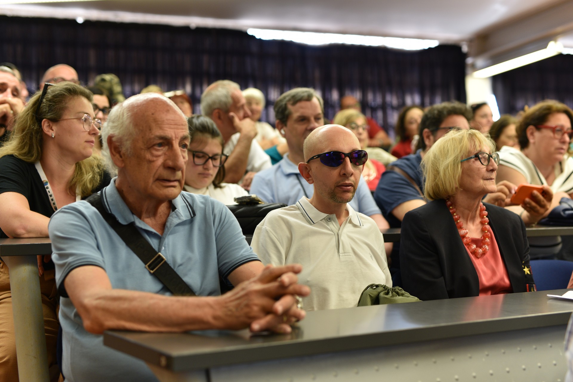 Una platea di persone che segue con attenzione i vari discorsi degli speaker intervenuti