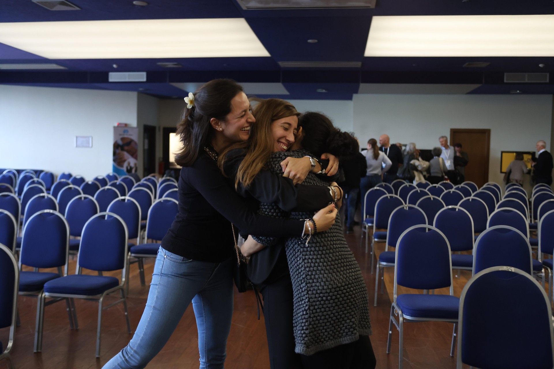 Tre volontarie si abbracciano sorridendo, condividendo un momento di vicinanza e collaborazione. L’immagine rappresenta solidarietà, impegno sociale e il valore del volontariato a sostegno delle persone più fragili.