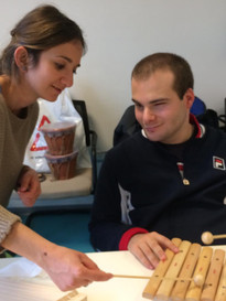 Attività di musicoterapia alla Sede Territoriale di Roma: un giovane utente suona uno xilofono affiancato dall'operatrice