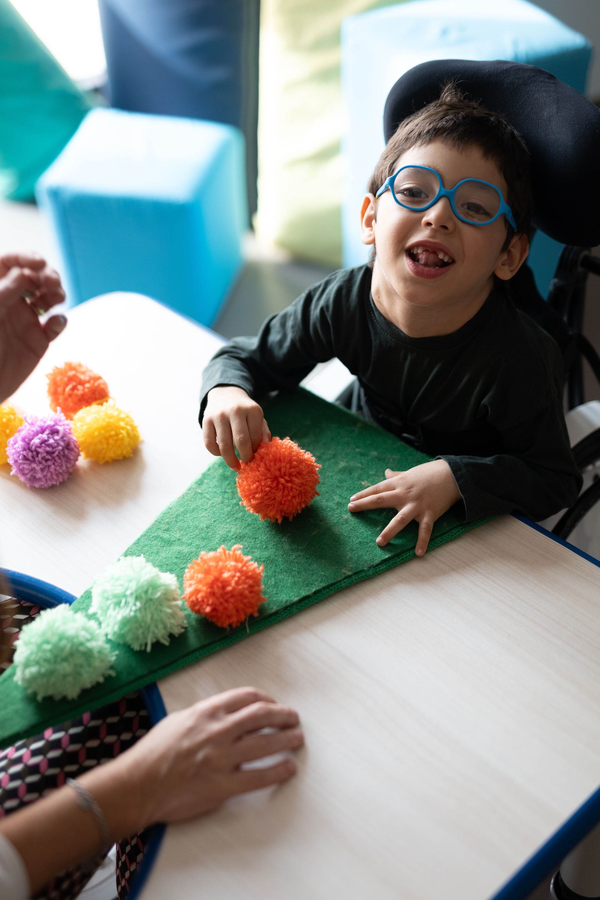 Nicola, un bimbo con ipovisionee problemi motori, sta facendo il primo lavoretto di Natale alla Lega del Filo d'Oro