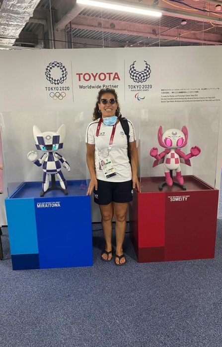 Matilde sorride posando per fotografo tra le mascotte delle Olimpiadi di Tokio