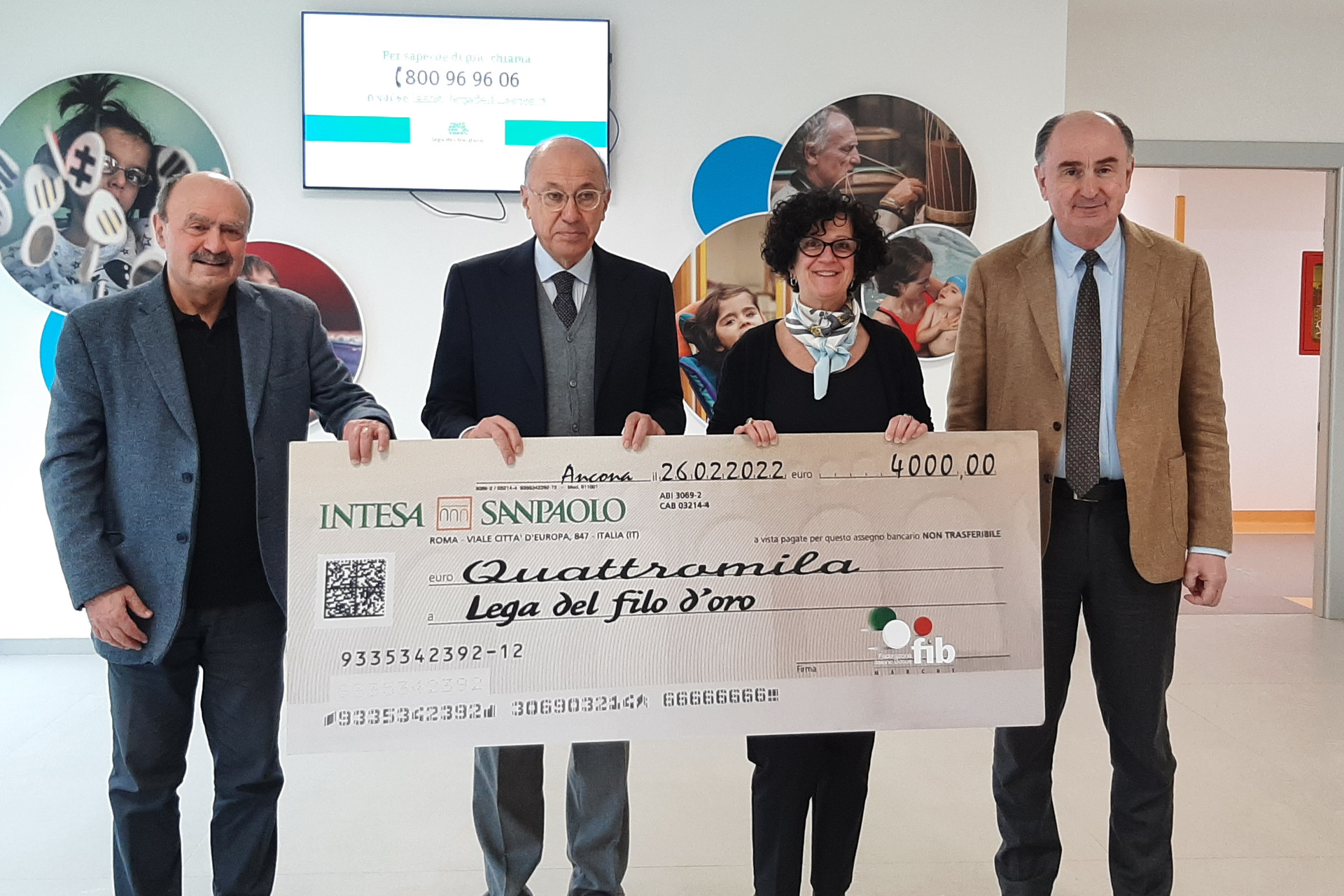 Il Presidente della Lega del Filo d'oro regge, insieme ad un altro uomo, un grosso assegno simbolico recante la scritta dell'ammontare di una donazione di quattromila euro.