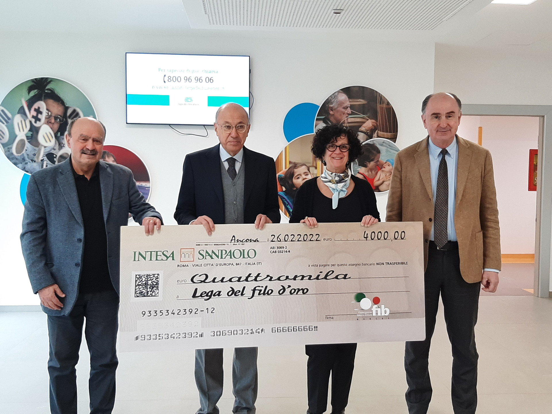 Il Presidente della Lega del Filo d'oro regge, insieme ad un altro uomo, un grosso assegno simbolico recante la scritta dell'ammontare di una donazione di quattromila euro.