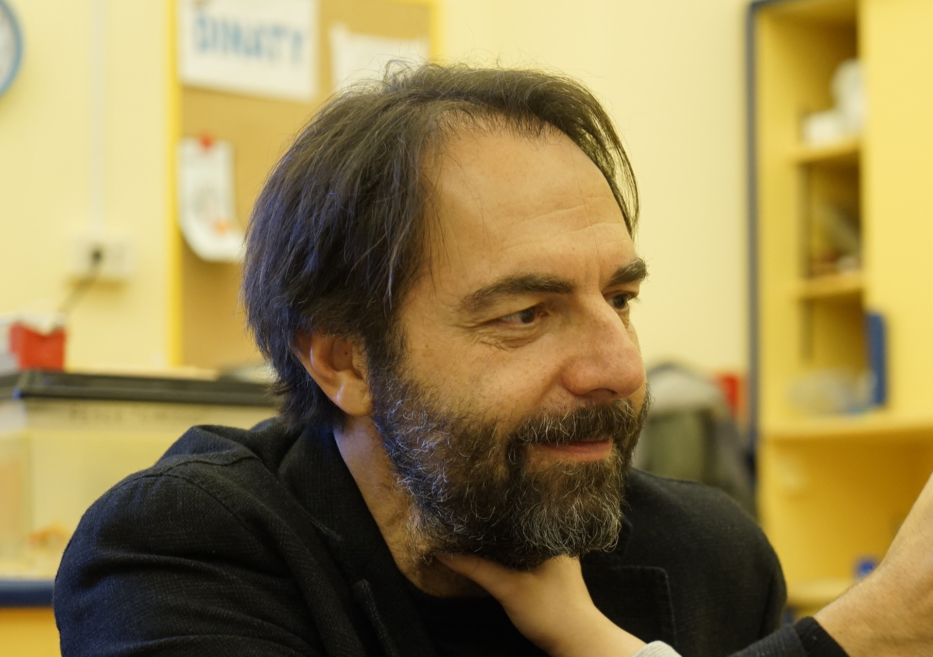 Neri Marcorè fa una carezza sul viso del piccolo Francesco, che a sua volta sta esplorando il suo volto con la mano