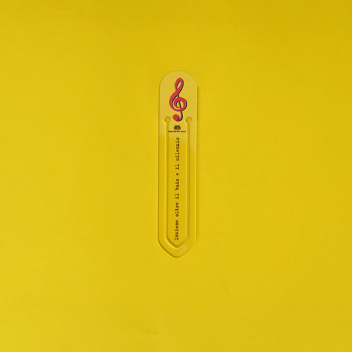 Still life su sfondo giallo della bomboniera segnalibro chiave di violino rossa 11
