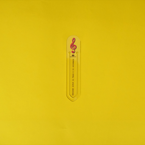 Still life su sfondo giallo della bomboniera segnalibro chiave di violino rossa 14