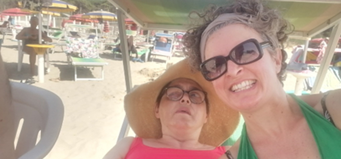 Anna, volontaria del Centro della Lega del Filo d'Oro di Modena, insieme ad un utente al mare