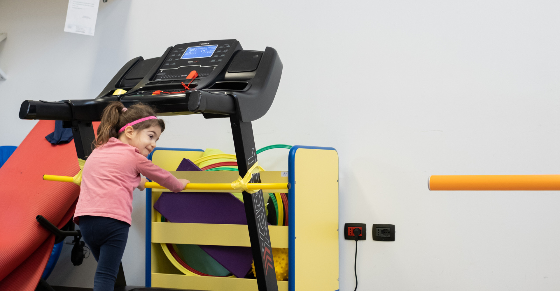 Asia, una bimba utente della Lega del Filo d'Oro,che cammina su un tapis roulant.