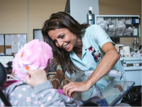 Francesca Francinella, infermiera della Lega del Filo d'Oro, si prende cura sorridendo di un utente in carrozzina