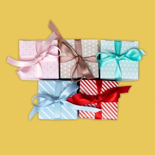 Bomboniere Pastello: foto di gruppo. Bomboniere cubiche in cartoncino bianco decorate con stampe di colori e fantasie diverse (rossa, azzurra, rosa, tortora, acquamarina) e fiocchetto in raso in tinta 30