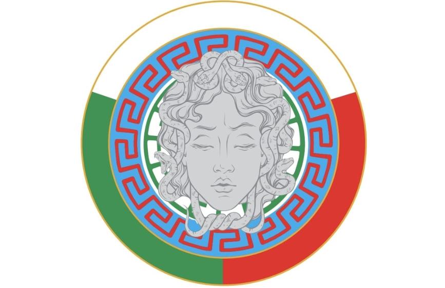 L'immagine mostra un medaglione circolare che incorpora i colori della bandiera italiana (verde, bianco, rosso) sul bordo esterno. Al centro, è raffigurato il volto di Medusa con i serpenti al posto dei capelli, circondato da una doppia cornice con motivi a meandro in blu e rosso.